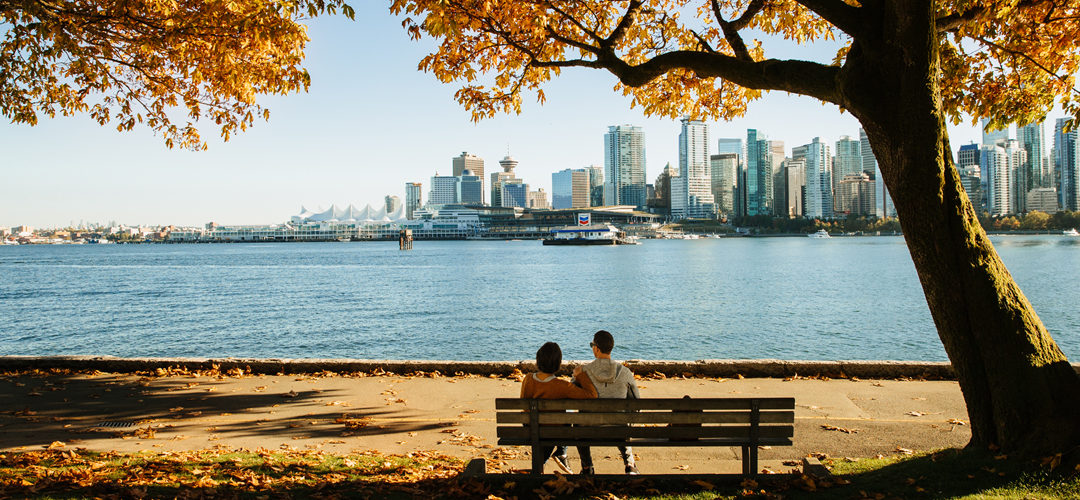 A couple sitting on the sea wall in Coal Harbour, Vancouver