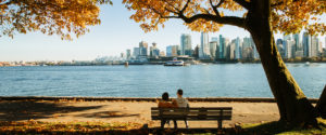 A couple sitting on the sea wall in Coal Harbour, Vancouver