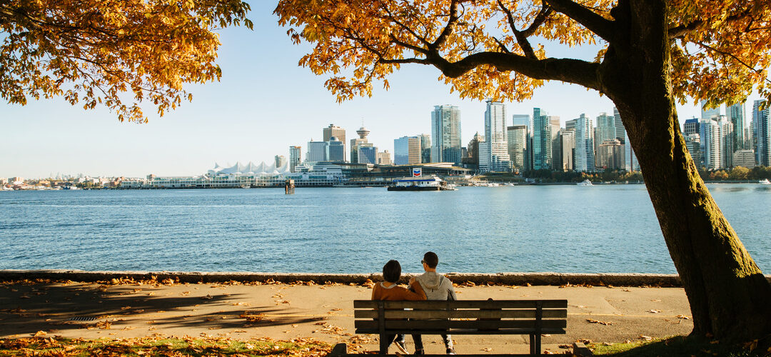 Couple on bench in Stanley Park with leaves changing colour