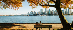 Couple on bench in Stanley Park with leaves changing colour